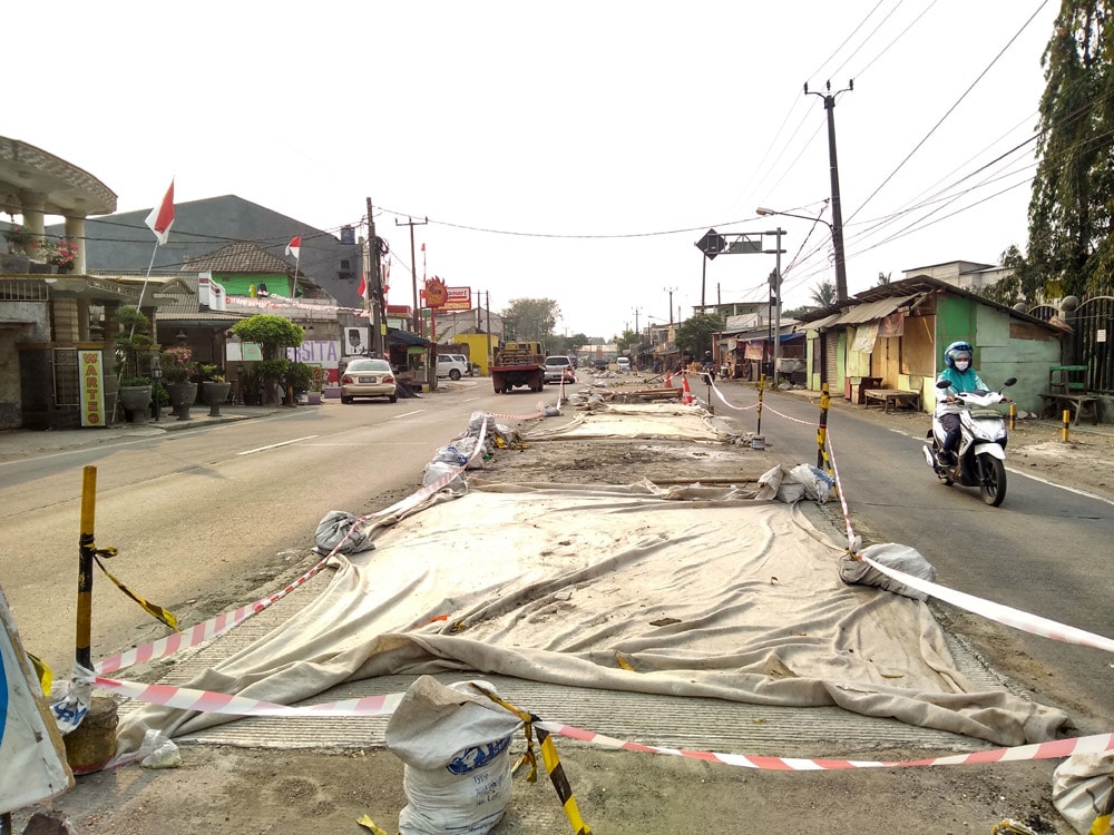 instalasi geotextile di jalan raya serang